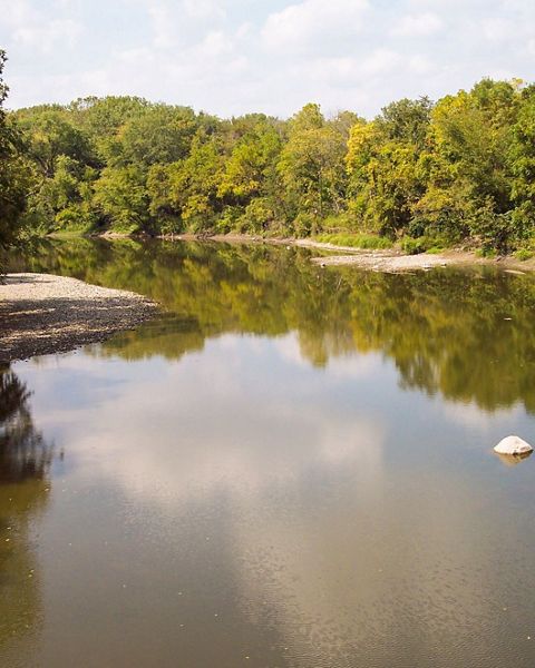 The placid waters of the Boone River are bordered by dense forests.