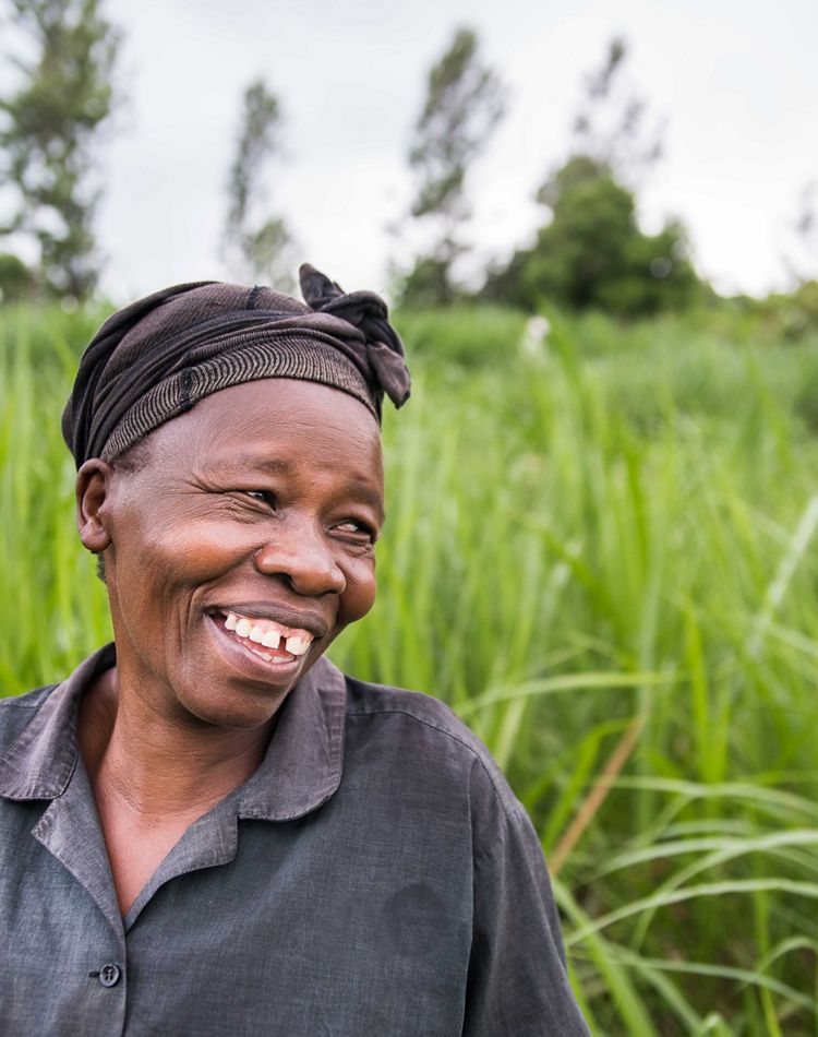 A woman smiles wide while looking to left of the camera