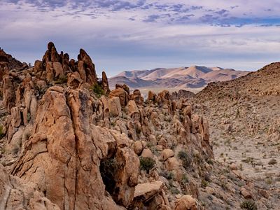 Rolling mountains peek out behind rocky escarpments and stacked stones.