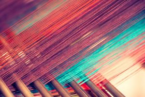 Multicolored straight strands texture background, sewing equipment, loom equipment at a garment factory.