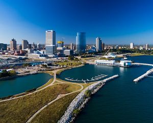 Aerial image of Milwaukee skyline on a blue sky day with Discovery World and Lakeshore State Park in the foreground.