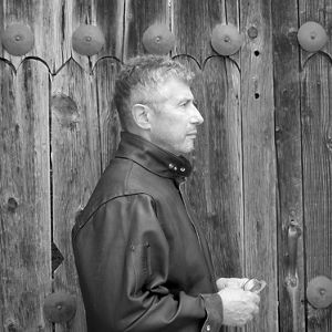 Black & white image of profile of a man in leather jacket.
