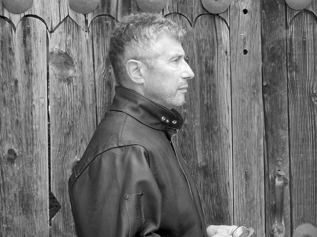 Black & white image of profile of a man in leather jacket.