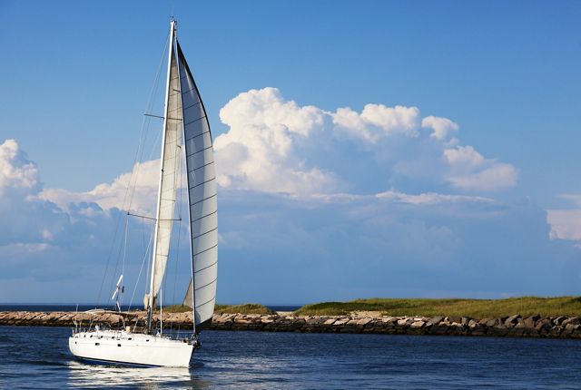 A sailboat on the water with land in the distance.