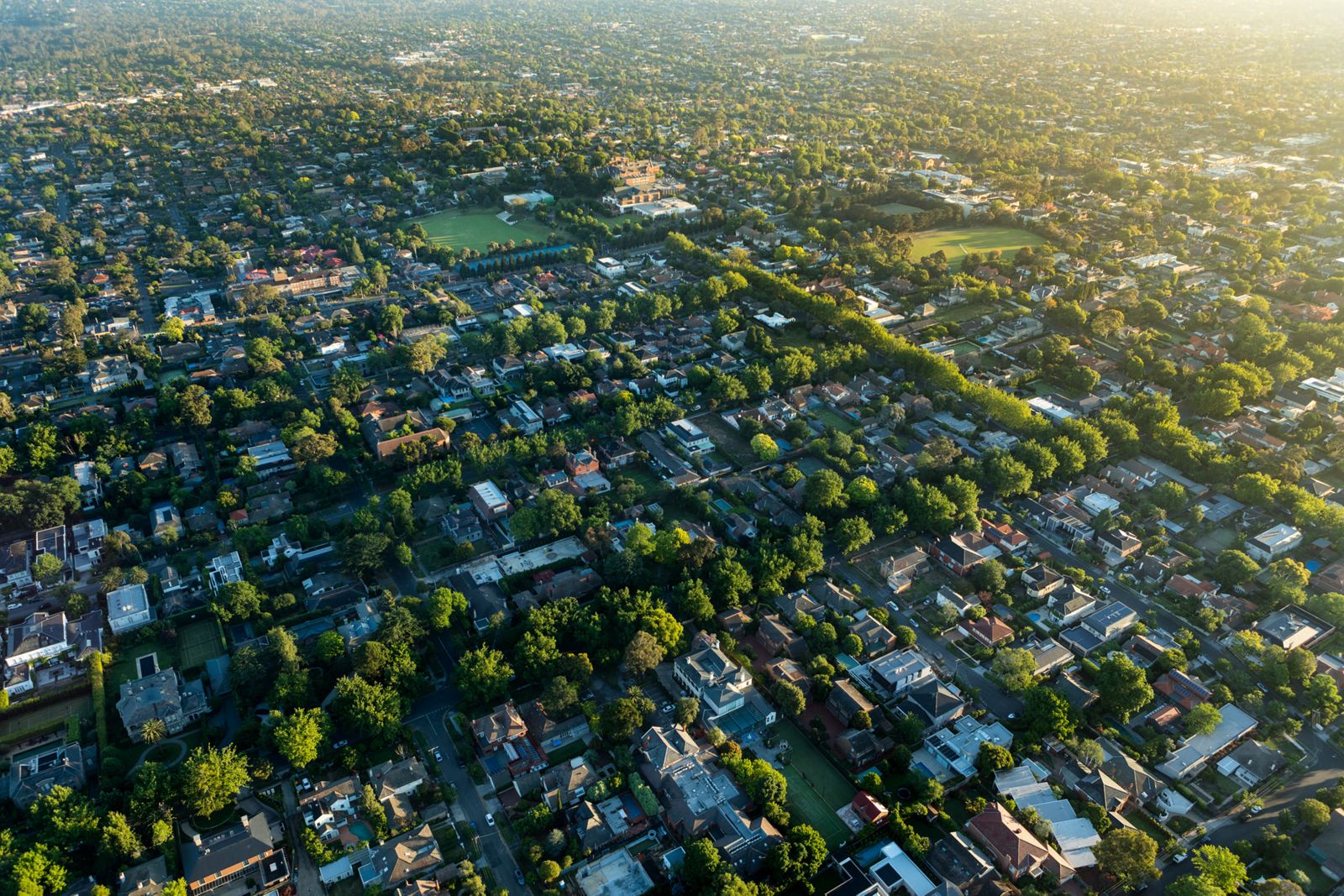 aerial view of suburban neighborhood with houses and buildings and lots of trees throughout