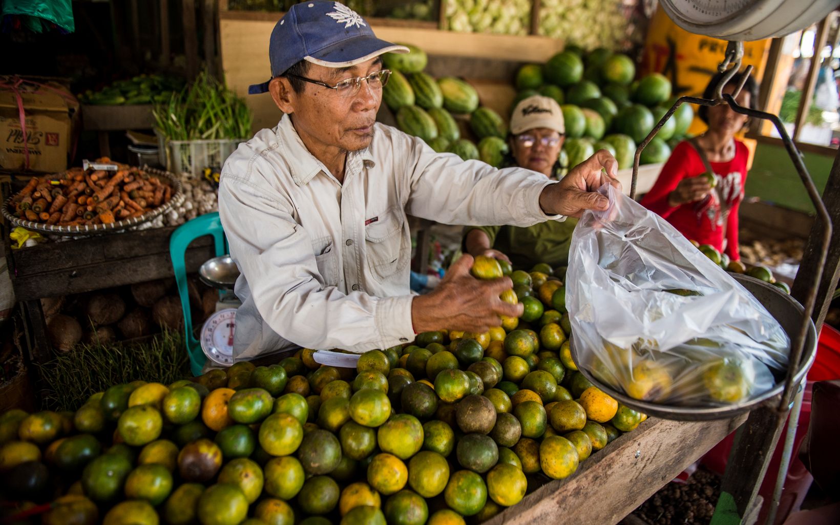 Vendedor de Fruta Un vendedor de frutas pesa la fruta en Kalimantan Oriental, Indonesia © Nick Hall