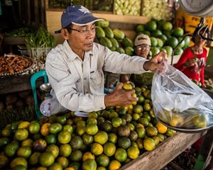 a man weighs fruit at a fruit stand
