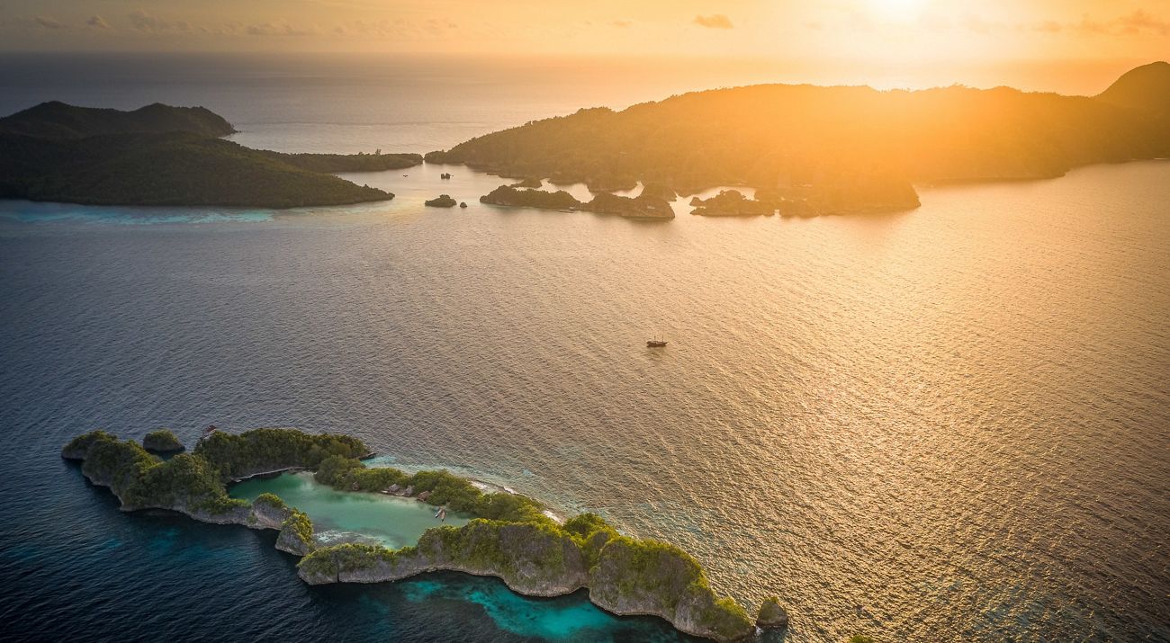 aerial of a coral reef sticking out of sun drenched waters in Indonesia