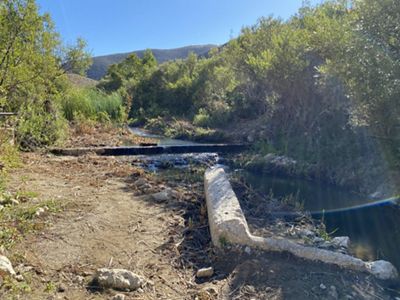 Blocked waterway with logs and other debris on Jalama Creek. Before.