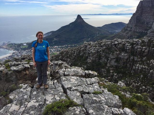 Jessica Dietrich standing on a cliff overlooking the shores of Cape Town, South Africa.