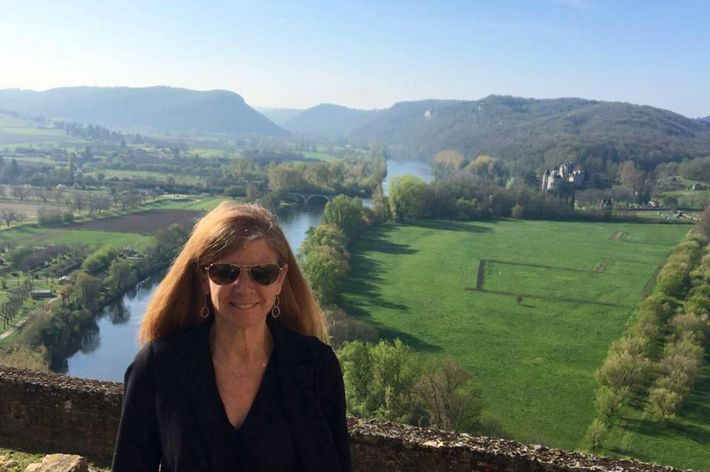 Candid photo of VVCR program director Jill Bieri. A smiling woman wearing sunglasses stands at an overlook. A narrow river winds through an open green field below her.
