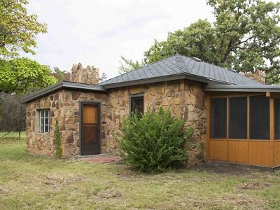 A stone cabin stands in a clearing.