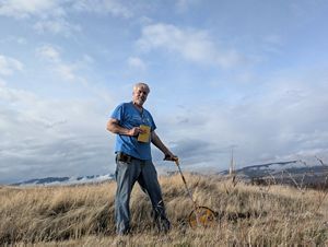 A man standing against the mountains.
