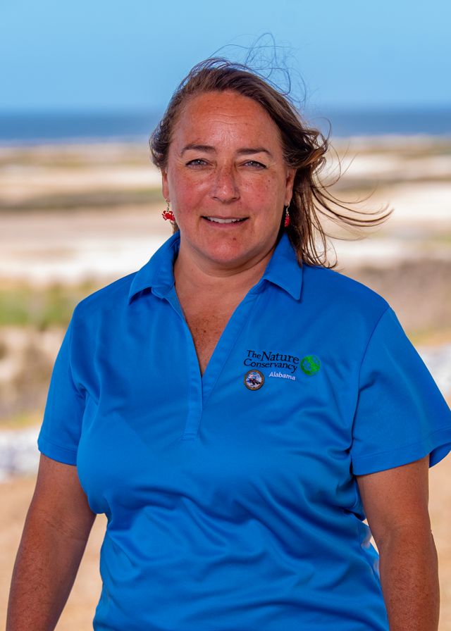  Headshot of Judy Haner in front of a sandy shore.