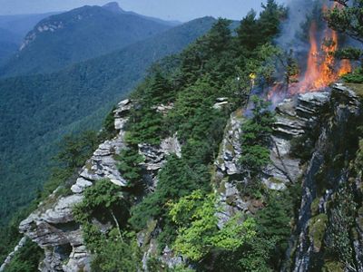 View of the mountains and fire running through the top of a rock.