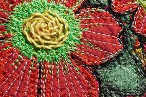 Closeup of colorful red flower stitched on backpack.