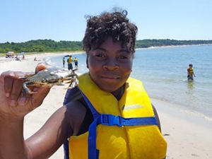 A girl holds up a crab at the Virginia Coast Reserve