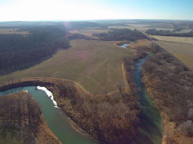 Aerial view of river winding through prairie fields and cultivated cropland.