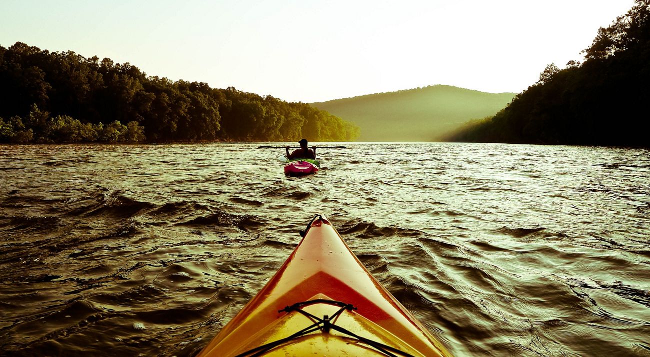 Two kayaks floating down a river.
