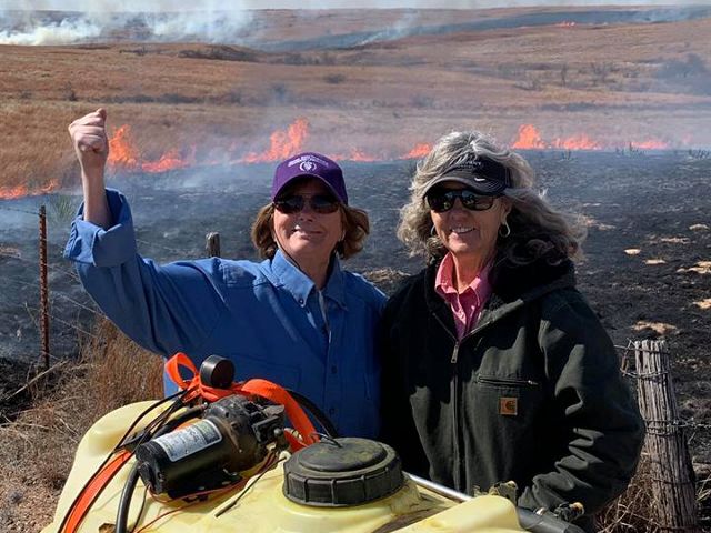 Two female ranchers conducting a prescribed burn.