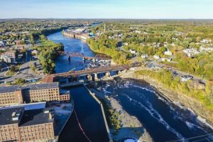 An aerial view of a dam on a river running through Waterville, Maine.