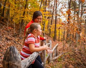 A family stands at a railing on a hiking trail surrounded by fall colors in Kentucky.