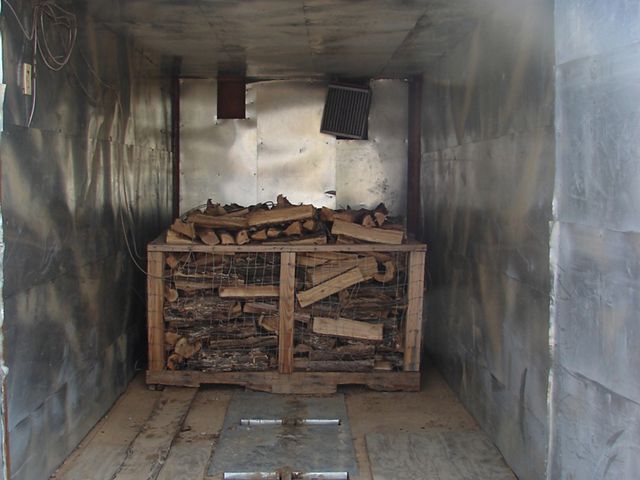Wood is piled up inside of a small metal space.