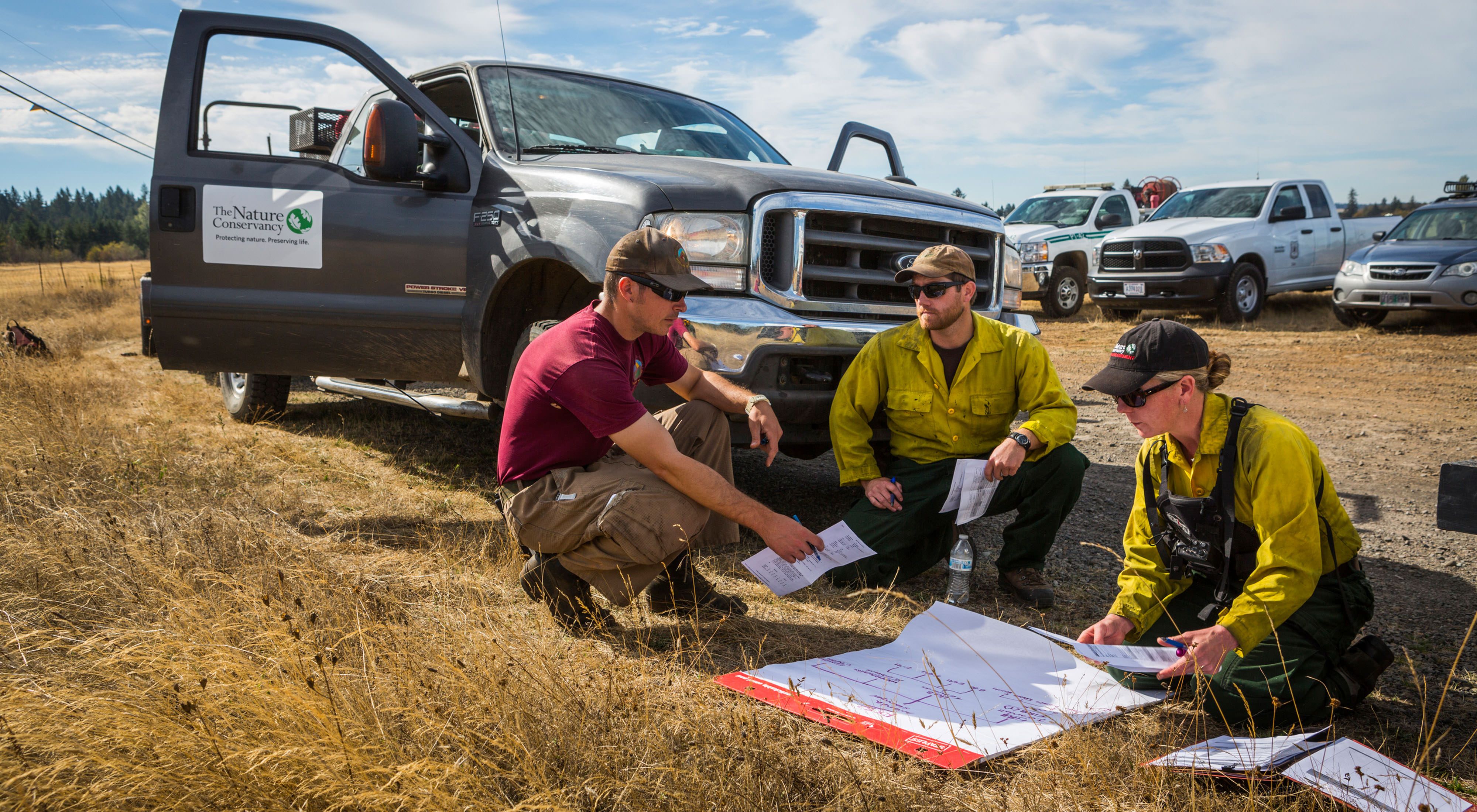 September 2015. Jeff Crandall (left) and Oregon Fire Manager (far right) plan the day's controlled burn in Kingston Preserve in Oregon.