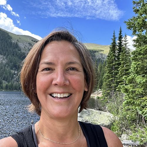 Selfie of Massachusetts State Director Kris Sarri in front of forested rocky mountains in Colorado.