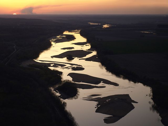 Aerial view of the Kansas River with a low sun on the horizon.