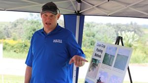 Man in blue shirt giving a presentation on soil health.