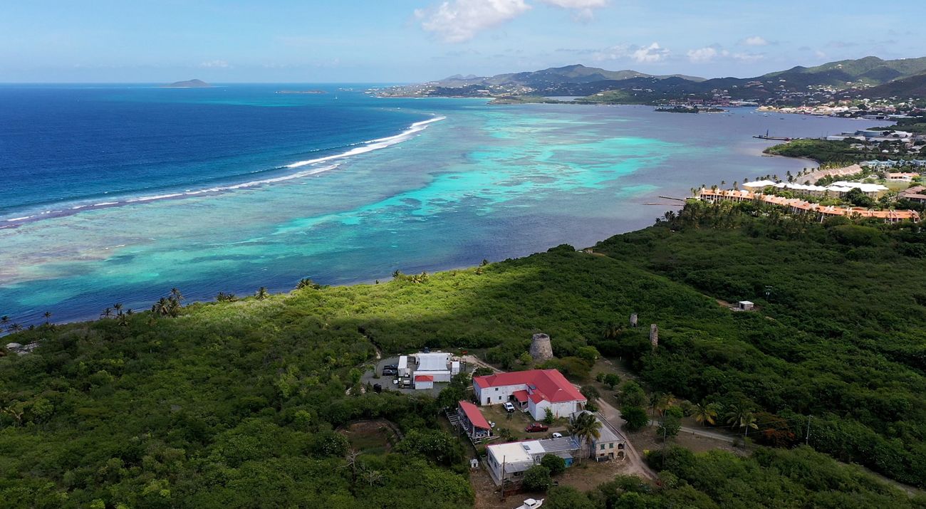 Aerial view of a tropical sea, building, and island.