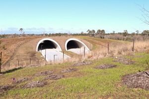 A large brown hill with two entrances for cars beneath the hill.