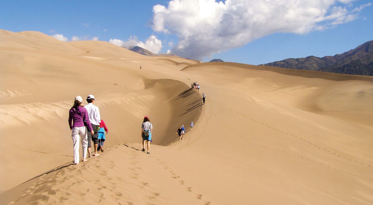 Visitors explore and play in the sand dunes