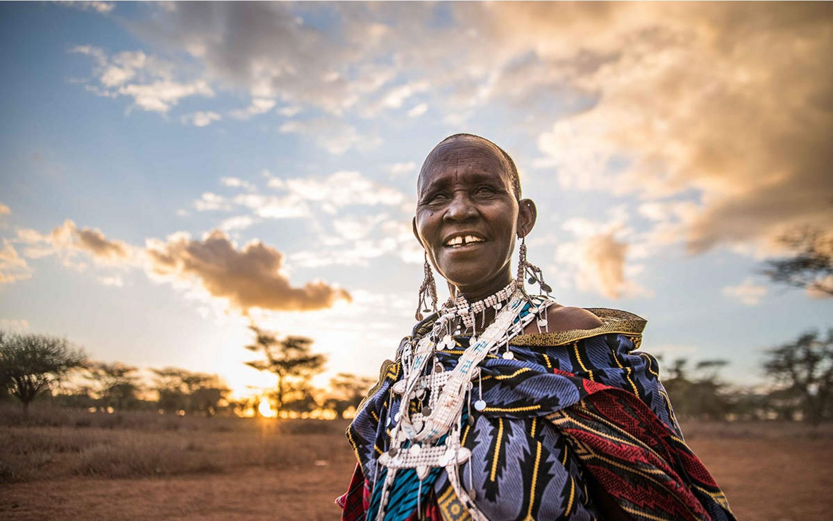 Woman in traditional Maasai clothing looking at the camera.