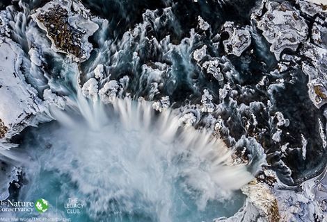 an aerial image of a huge, icy waterfall