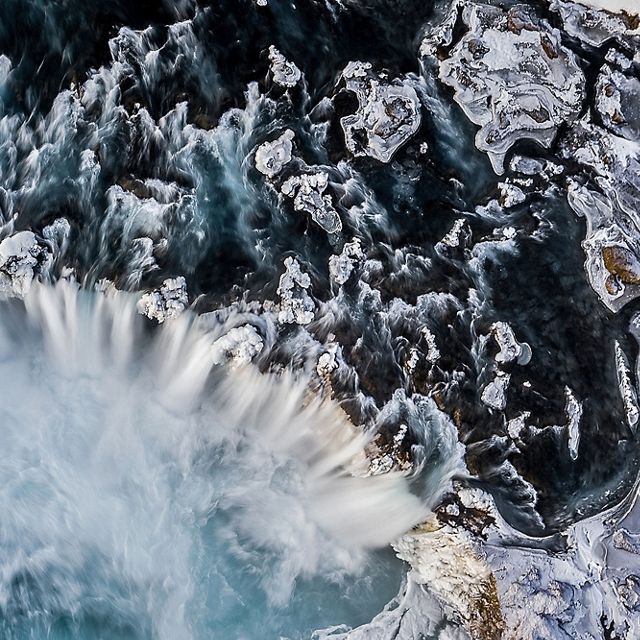 an aerial image of a huge, icy waterfall