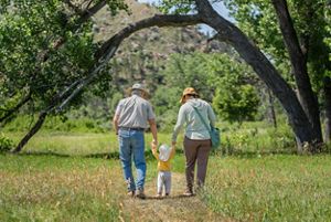 A family of 3 walking along a path.
