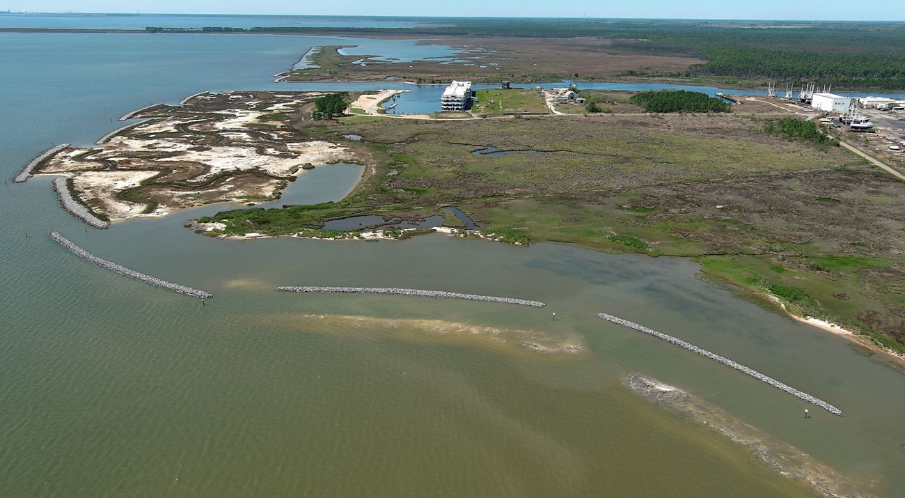 An aerial view of a coastal restoration project highlights jetties and other elements.