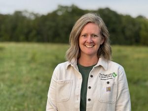 A woman wears a white Nature Conservancy shirt.