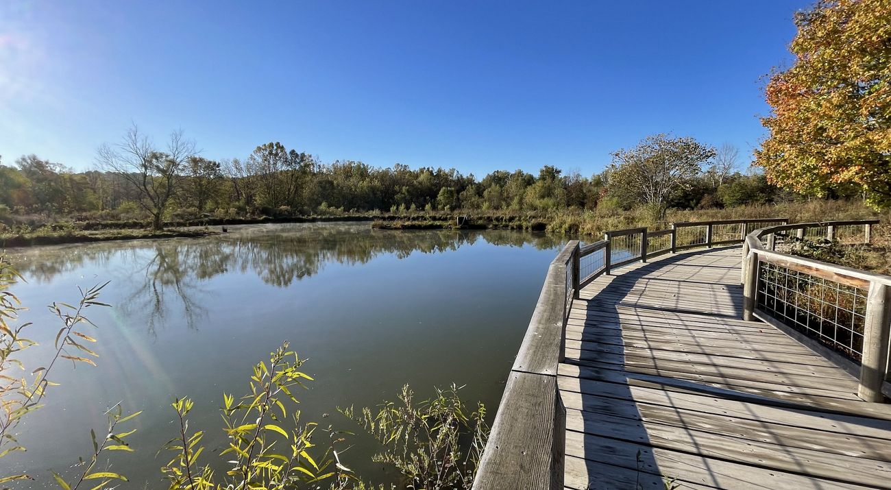 Pond at Logan Springs Preserve with a boardwalk curving around its edge.