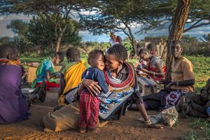 Ntipiyon Nonguta and son Bernard relax with their neighbors as they make beaded belts in Laikipia, northern Kenya. Their stunning designs are available worldwide.