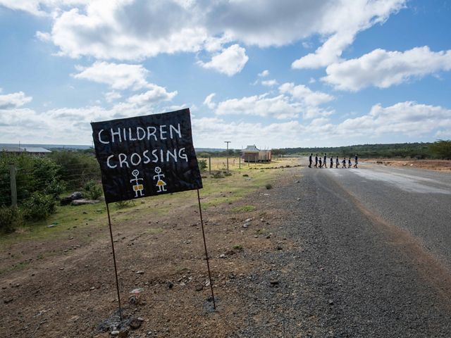 Crossing sign on tarmac road near Amani School.