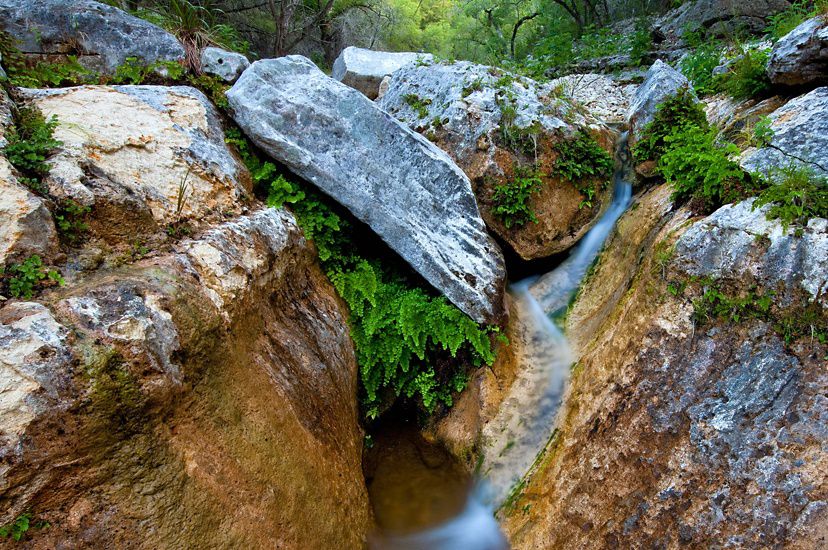 Photo of a small stream spilling over rocks at Love Creek in Texas.