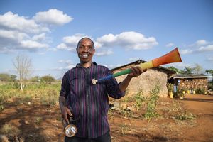 A person holding a flashlight and colorful plastic horn.