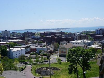 An aerial view of downtown Lynn with the ocean and Nahant beach and neighborhood in the background.