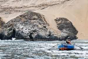 Fishing boat at sea with the coast in the background.