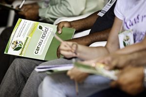 Carpeta sobre el Cadastro Ambiental Rural (CAR) en manos de asistentes a una reunión, en Brasil. 