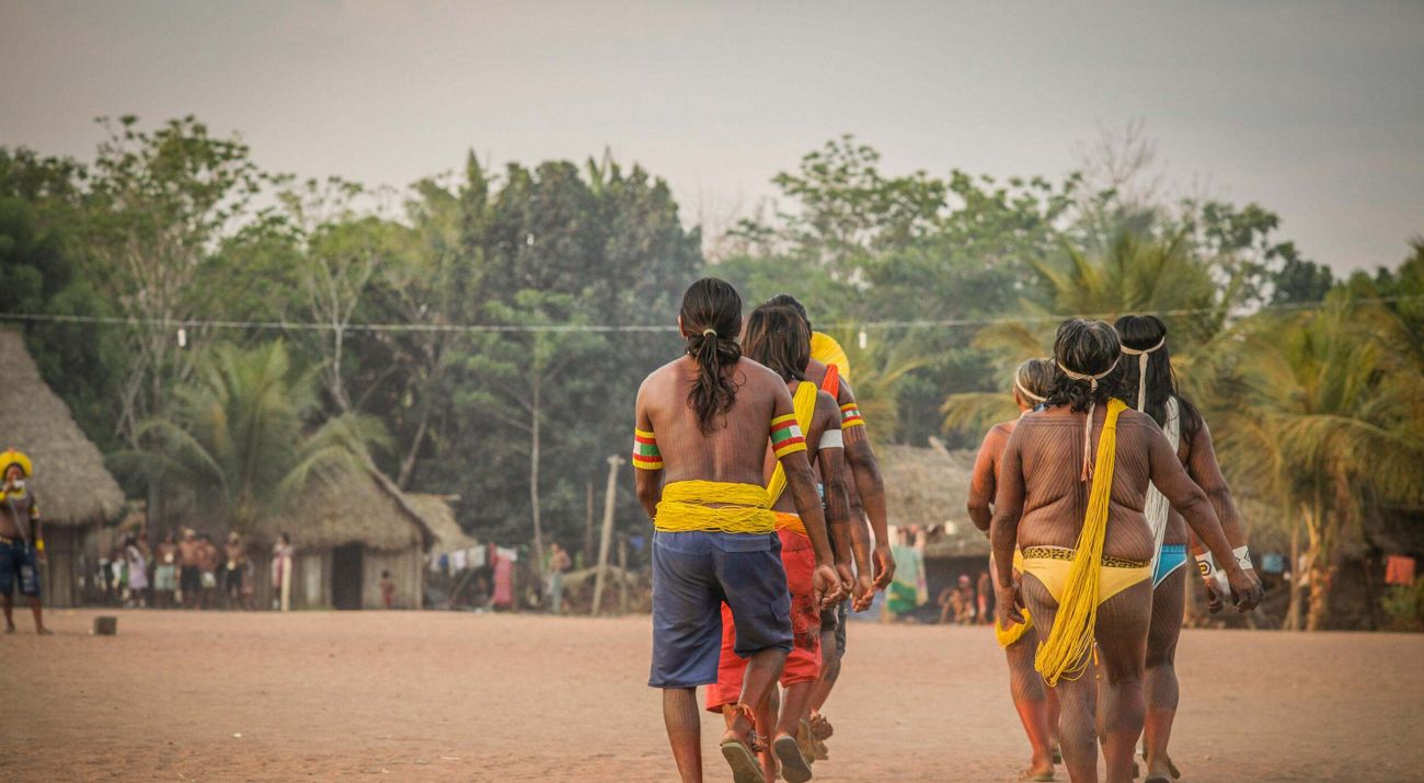Indígenas fazem dança em aldeia.