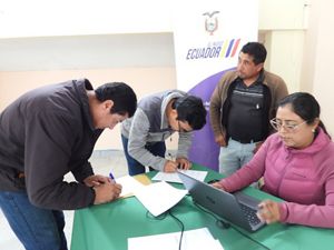 Dos personas firmando un documento.